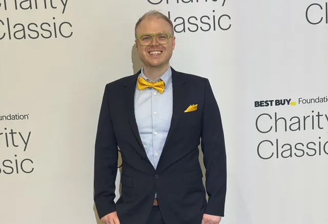 Augustus Willman in a dark suit with a canary yellow bow tie at the Best Buy Foundation Charity Classic